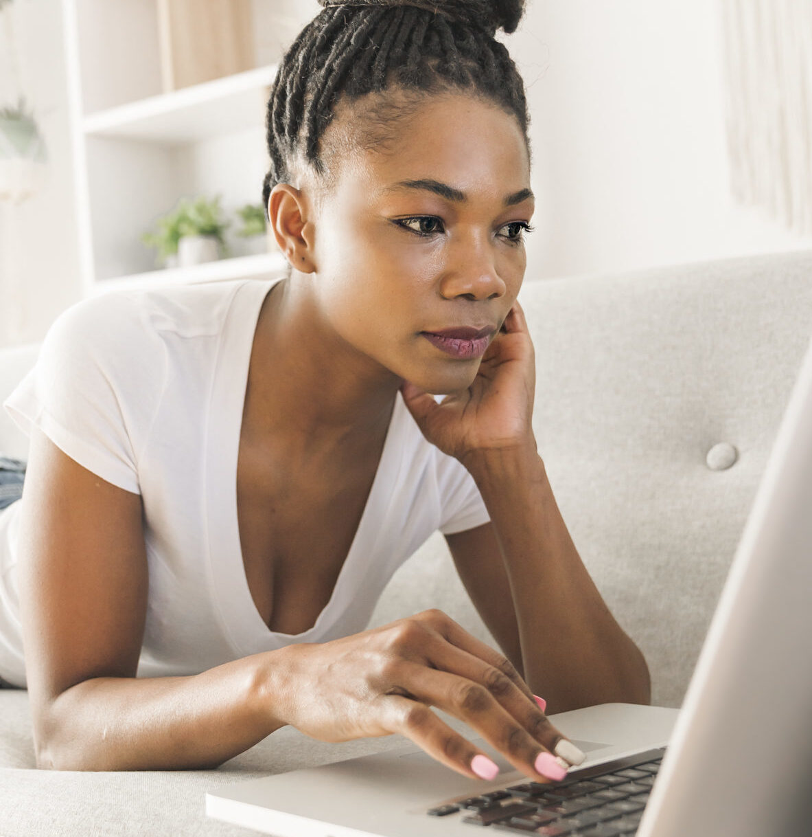 Portrait Of A African Woman Sit On The Sofa At Home Using Laptop